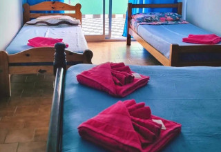 Habitación Hotel Cerdeña, doble superior donde se muestra una  cama estilo matrimonial muy prolijamente armada con una ventana con vista al exterior