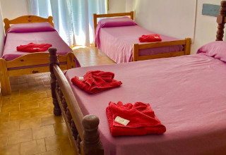 Habitación Hotel Cerdeña, doble superior donde se muestra una  cama estilo matrimonial muy prolijamente armada con una ventana con vista al exterior